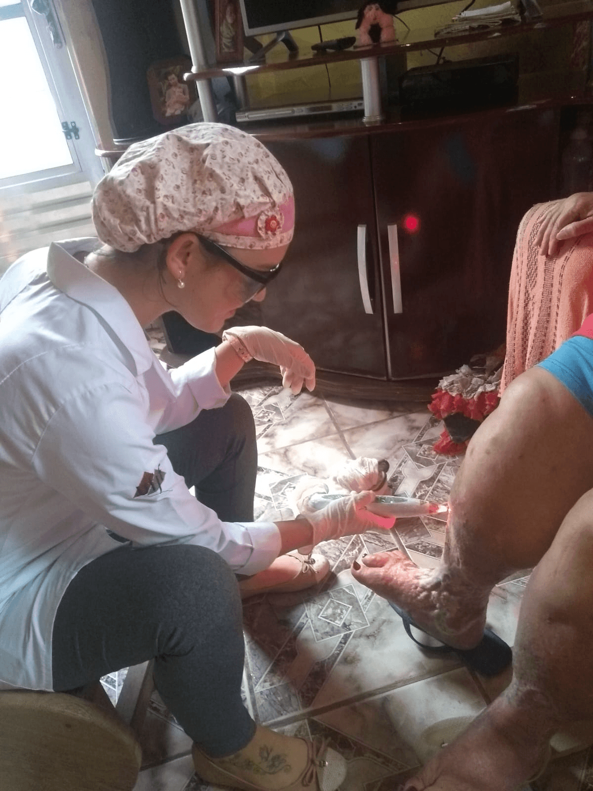 Bruna realizando atendimento domiciliar com laserterapia em Juiz de Fora